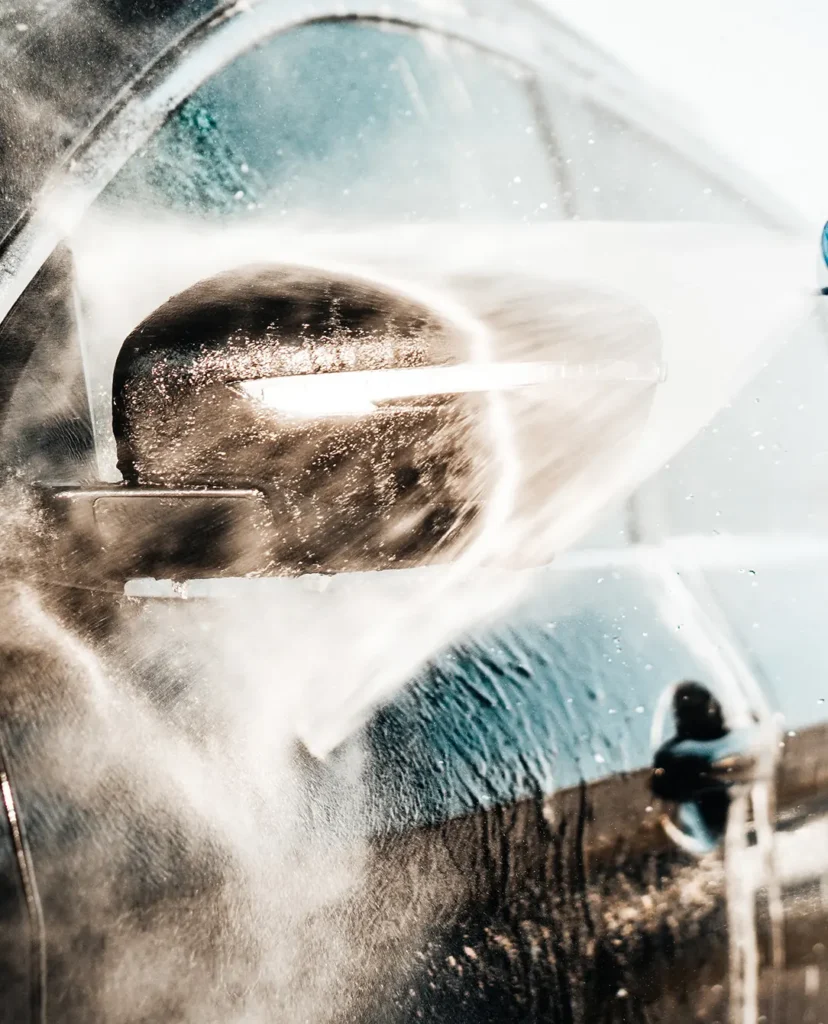 Een auto wordt gewassen met een krachtige waterstraal.